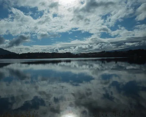 湖面に映る雲と山々。near nipponが掲げる持続可能な取り組みと自然との調和。