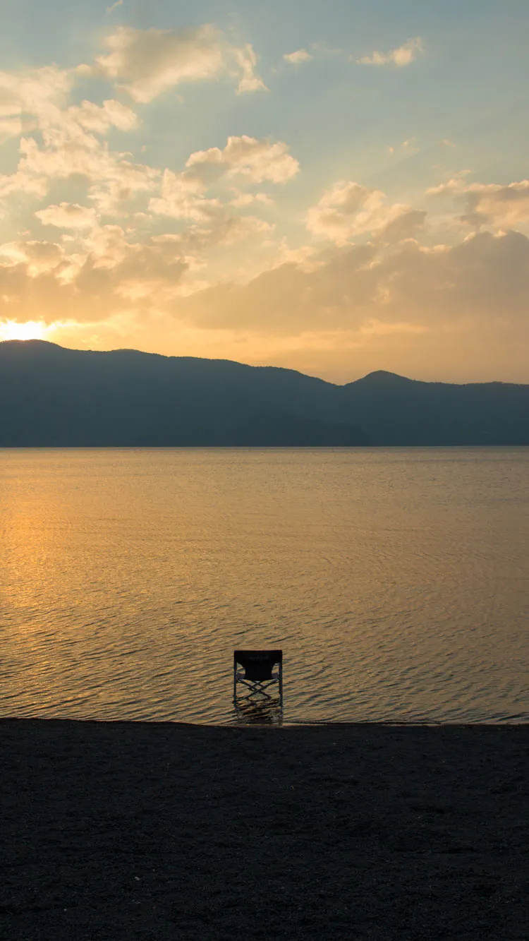 黄金色に輝く湖と折りたたみチェア。near nipponの長く愛用できるプロダクト哲学。